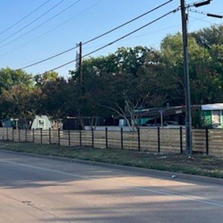 shot of fenced in manufactured home community along roadside