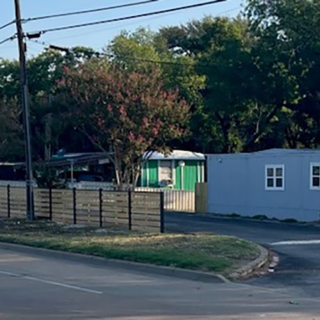 shot of fenced in manufactured home community along roadside