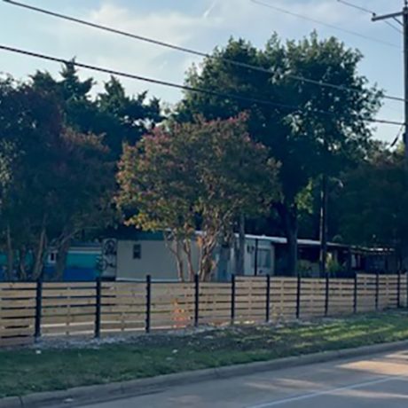 shot of fenced in manufactured home community along roadside